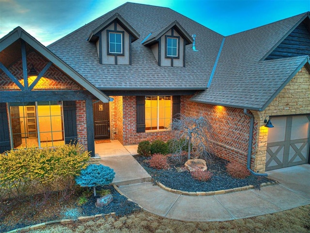 view of front of home featuring stone siding, roof with shingles, brick siding, and an attached garage