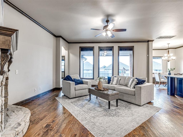 living room with baseboards, dark wood finished floors, visible vents, and crown molding