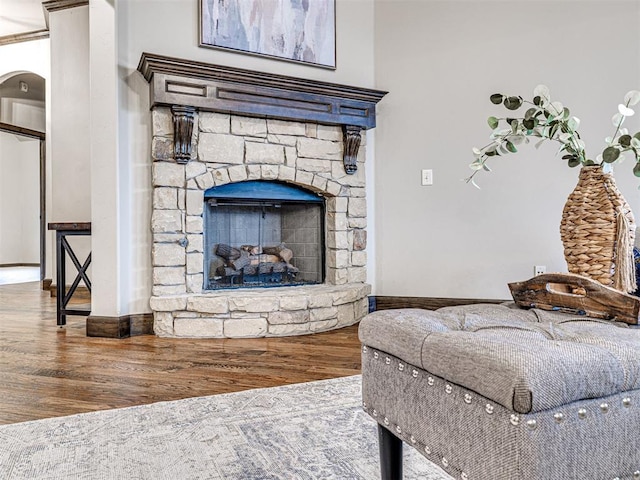 interior space with a fireplace, baseboards, and wood finished floors