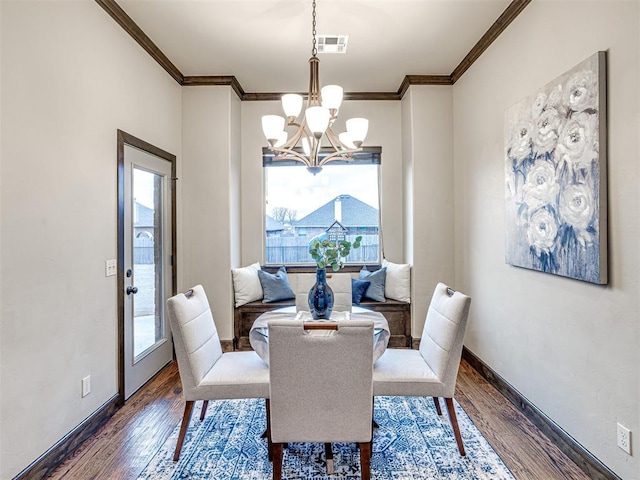 dining room featuring dark wood-style floors, baseboards, visible vents, and crown molding