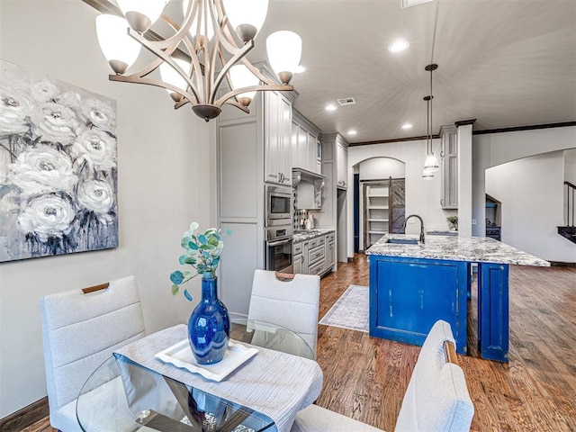 dining room featuring dark wood-style floors, arched walkways, crown molding, recessed lighting, and visible vents