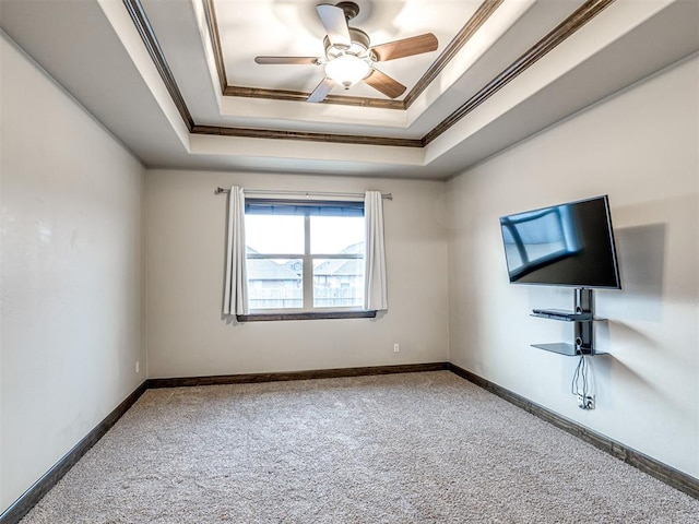 unfurnished room featuring carpet floors, baseboards, ornamental molding, and a raised ceiling