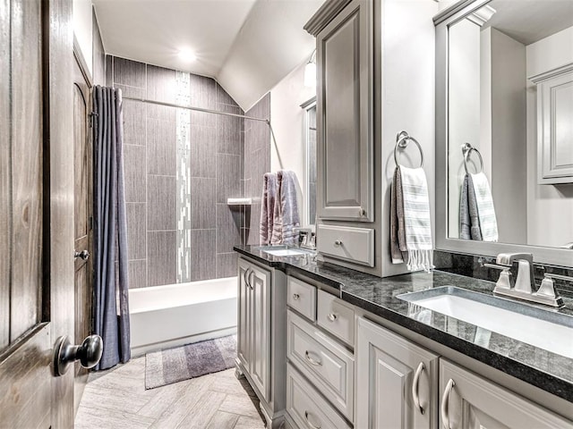 full bathroom featuring lofted ceiling, double vanity, a sink, and shower / bath combo with shower curtain