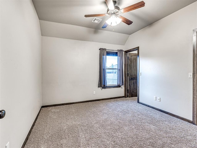 spare room with lofted ceiling, ceiling fan, visible vents, baseboards, and carpet