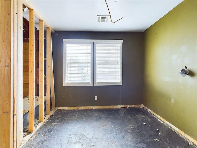 unfurnished room with baseboards and visible vents