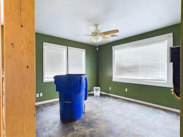 unfurnished room with visible vents, a ceiling fan, and baseboards