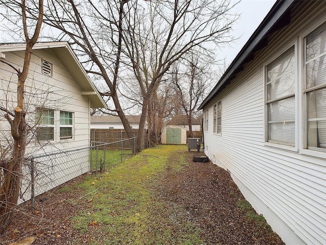 view of yard with a shed, fence, and an outdoor structure