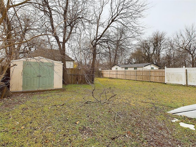 view of yard featuring an outbuilding, a shed, and a fenced backyard