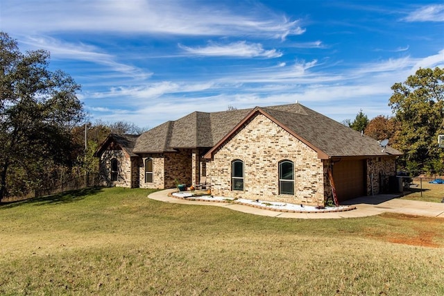 french provincial home featuring a garage, brick siding, concrete driveway, roof with shingles, and a front yard