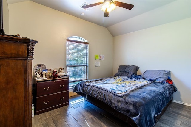 bedroom with dark wood finished floors, vaulted ceiling, baseboards, and ceiling fan