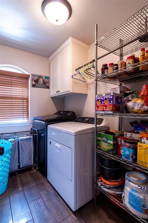 laundry area featuring cabinet space, dark wood-type flooring, and washer and dryer