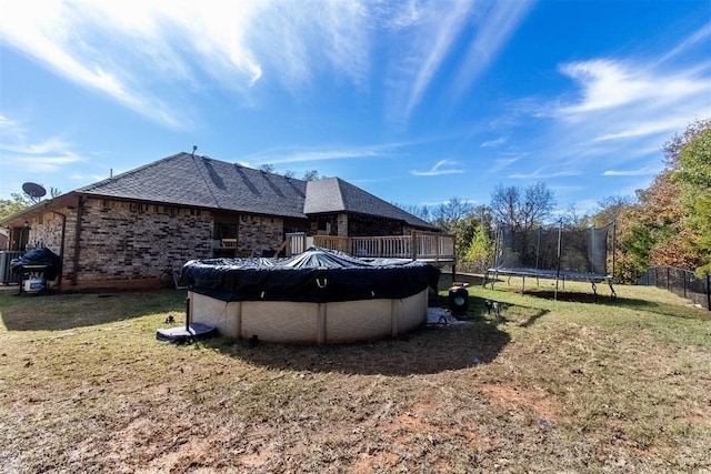 exterior space with a trampoline, a fenced in pool, and fence