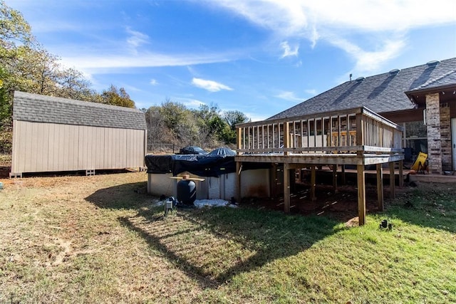 view of yard featuring an outbuilding, a shed, and a deck