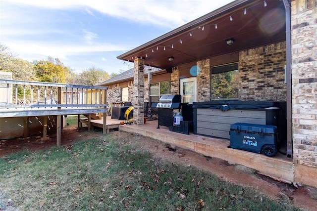 view of patio with a hot tub, a deck, and area for grilling