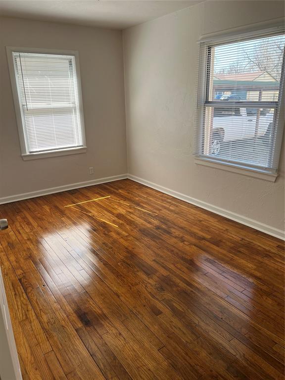 empty room with hardwood / wood-style flooring and baseboards