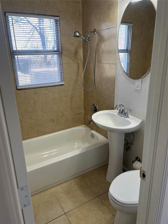 bathroom with shower / bathing tub combination, toilet, and tile patterned floors