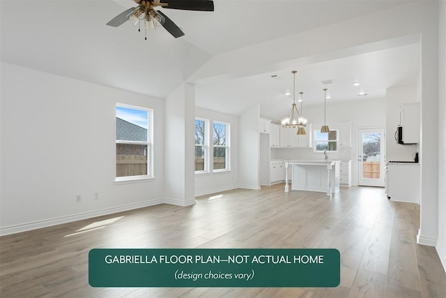 unfurnished living room with light wood-type flooring, baseboards, vaulted ceiling, and ceiling fan with notable chandelier