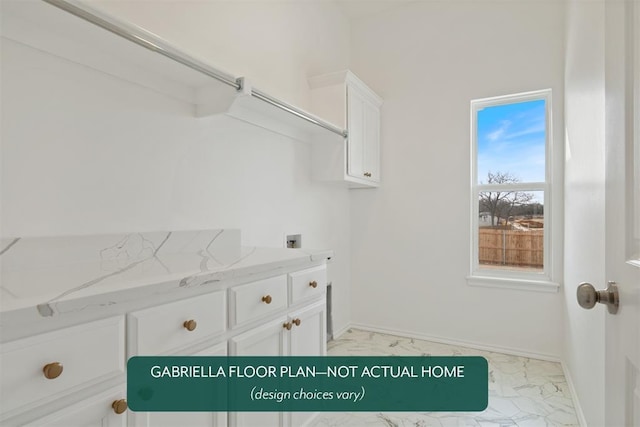 laundry room with marble finish floor, hookup for a washing machine, cabinet space, and baseboards