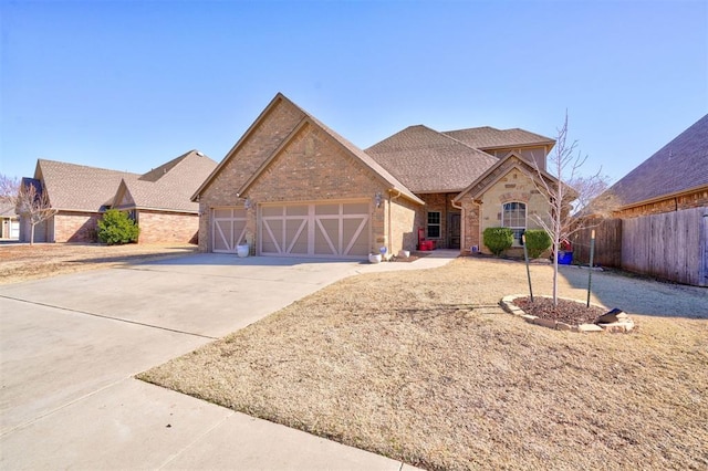 view of front facade with brick siding, concrete driveway, an attached garage, fence, and stone siding