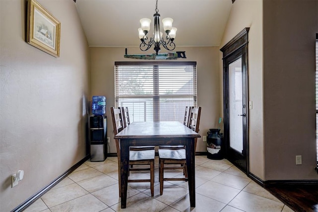 dining space featuring a notable chandelier, vaulted ceiling, baseboards, and light tile patterned flooring