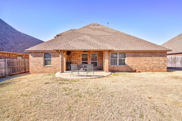 back of property with a patio area, a fenced backyard, a shingled roof, and brick siding