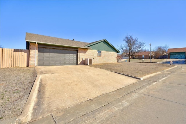 ranch-style house featuring a garage, brick siding, fence, concrete driveway, and roof with shingles