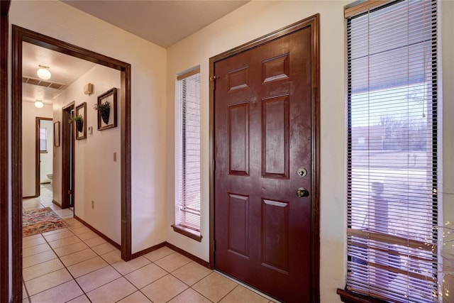 foyer with light tile patterned floors, baseboards, and visible vents