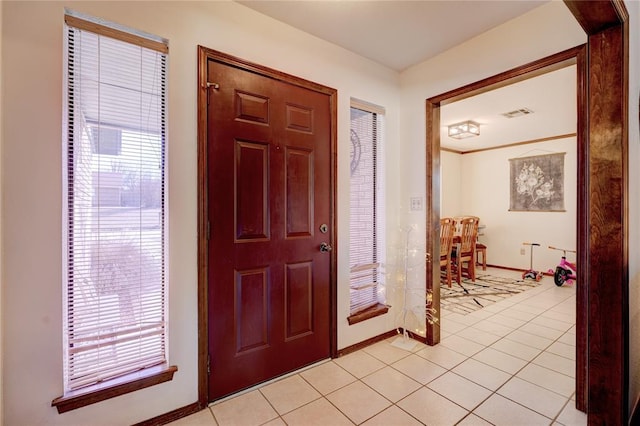 foyer entrance with light tile patterned floors, visible vents, and baseboards