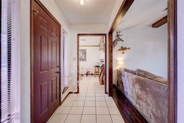 corridor with light tile patterned floors and beamed ceiling