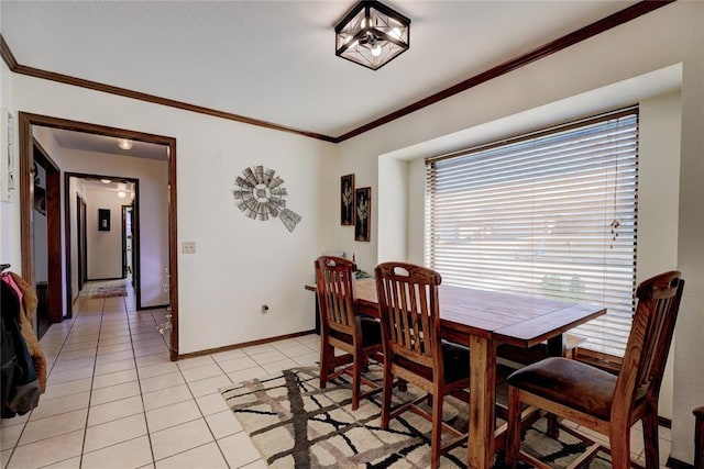 dining room with light tile patterned floors, baseboards, and ornamental molding