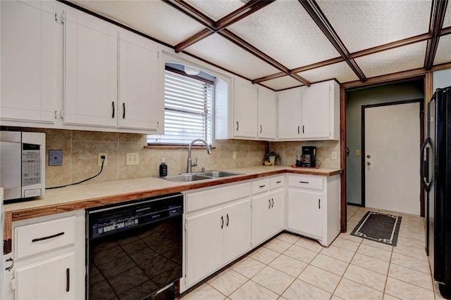 kitchen featuring white cabinets, light countertops, a sink, and black appliances