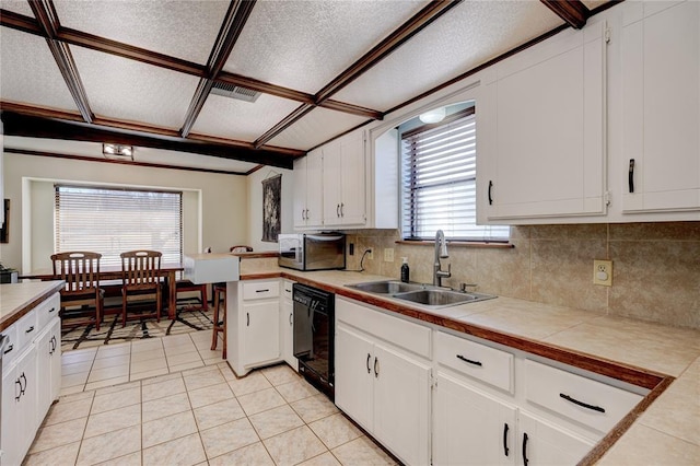 kitchen with dishwasher, stainless steel microwave, a sink, and white cabinetry