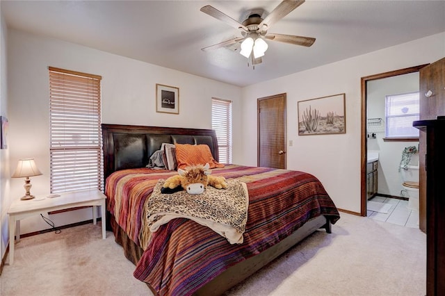 bedroom with baseboards, multiple windows, connected bathroom, and light colored carpet