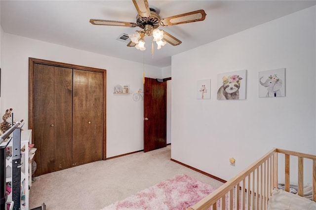 bedroom featuring a closet, light colored carpet, visible vents, ceiling fan, and baseboards