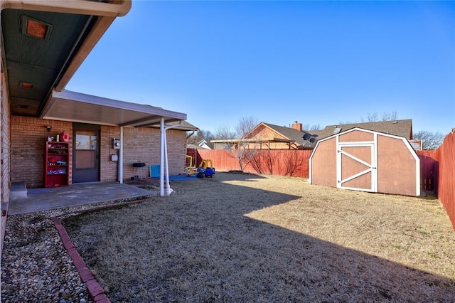 view of yard with a storage shed, a patio area, an outdoor structure, and a fenced backyard