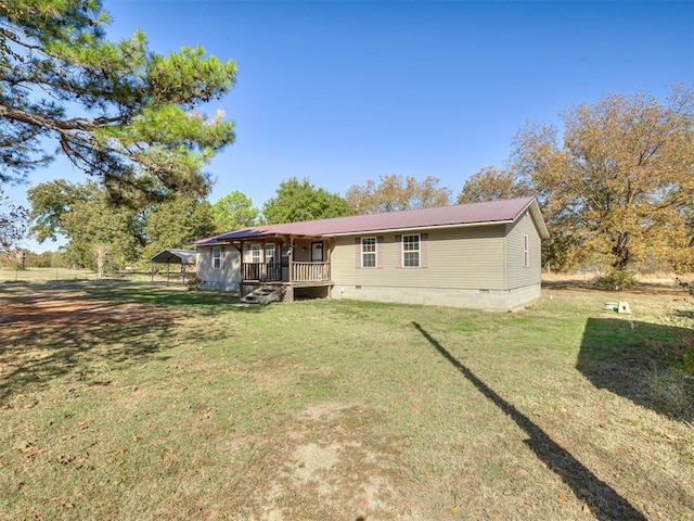 rear view of property featuring crawl space, metal roof, and a yard