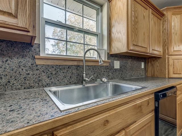 kitchen with tasteful backsplash, dishwasher, and a sink
