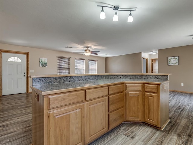 kitchen with baseboards, visible vents, tile counters, ceiling fan, and dark wood-type flooring