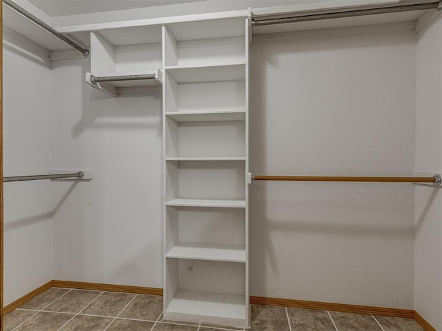 walk in closet featuring dark tile patterned floors