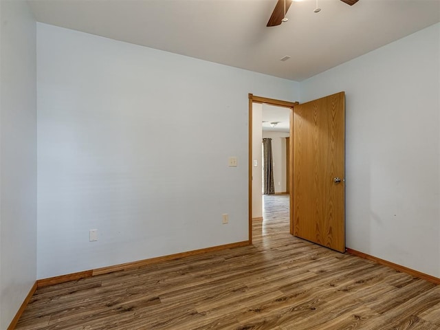 spare room with ceiling fan, baseboards, and wood finished floors