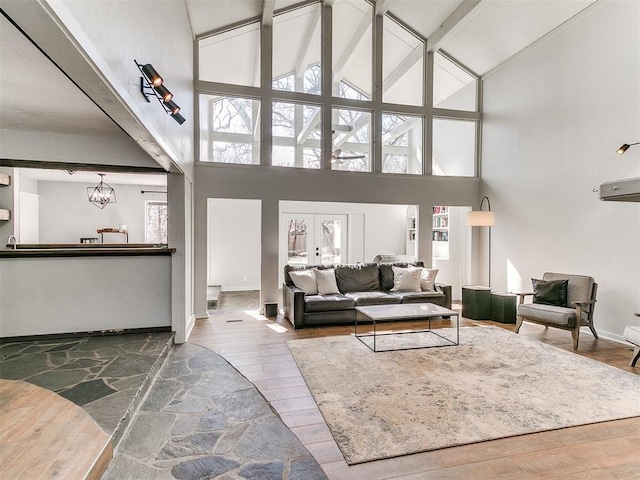 living room featuring baseboards, a towering ceiling, and wood finished floors