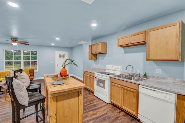 kitchen featuring dark wood-type flooring, light brown cabinets, a sink, a kitchen island, and white appliances