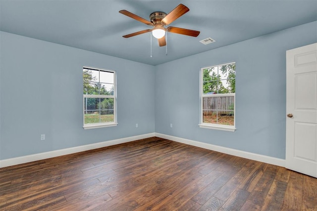 spare room with ceiling fan, baseboards, visible vents, and dark wood finished floors