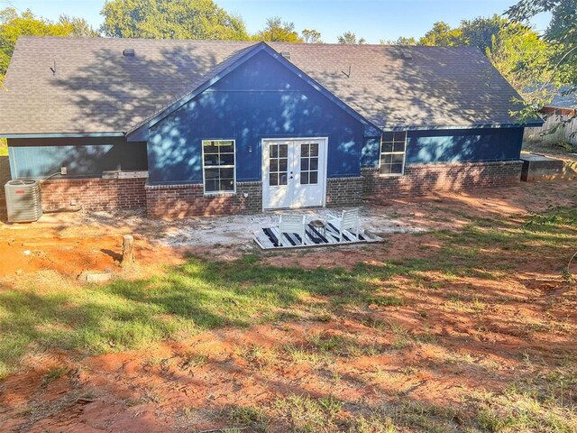 back of house with a patio area, a shingled roof, central AC unit, and brick siding