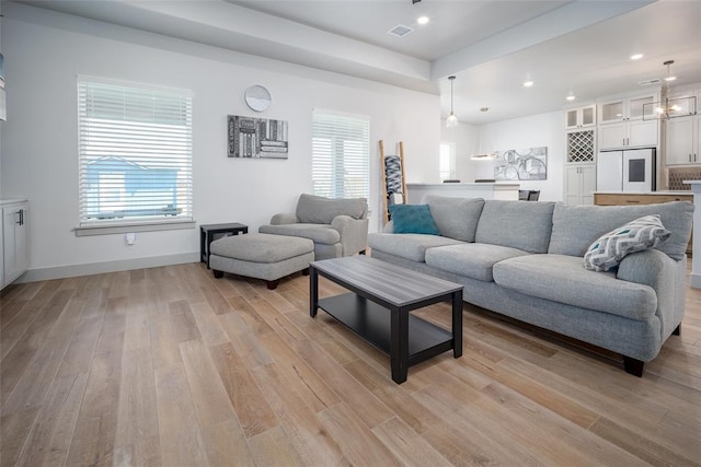 living room with a healthy amount of sunlight, light wood-style flooring, and visible vents