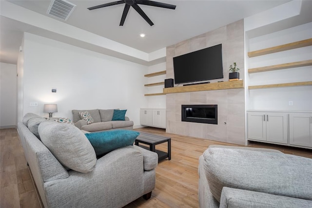 living room featuring recessed lighting, visible vents, a tiled fireplace, ceiling fan, and wood finished floors