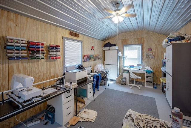 office area featuring a ceiling fan, vaulted ceiling, and wood walls