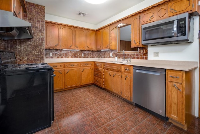 kitchen featuring brown cabinets, under cabinet range hood, stainless steel appliances, and a sink