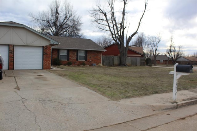 view of front of house featuring a garage, a front lawn, concrete driveway, and brick siding