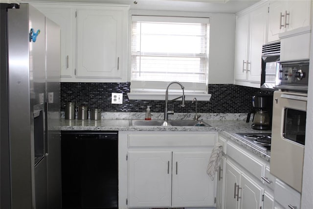 kitchen featuring appliances with stainless steel finishes, a sink, and white cabinetry